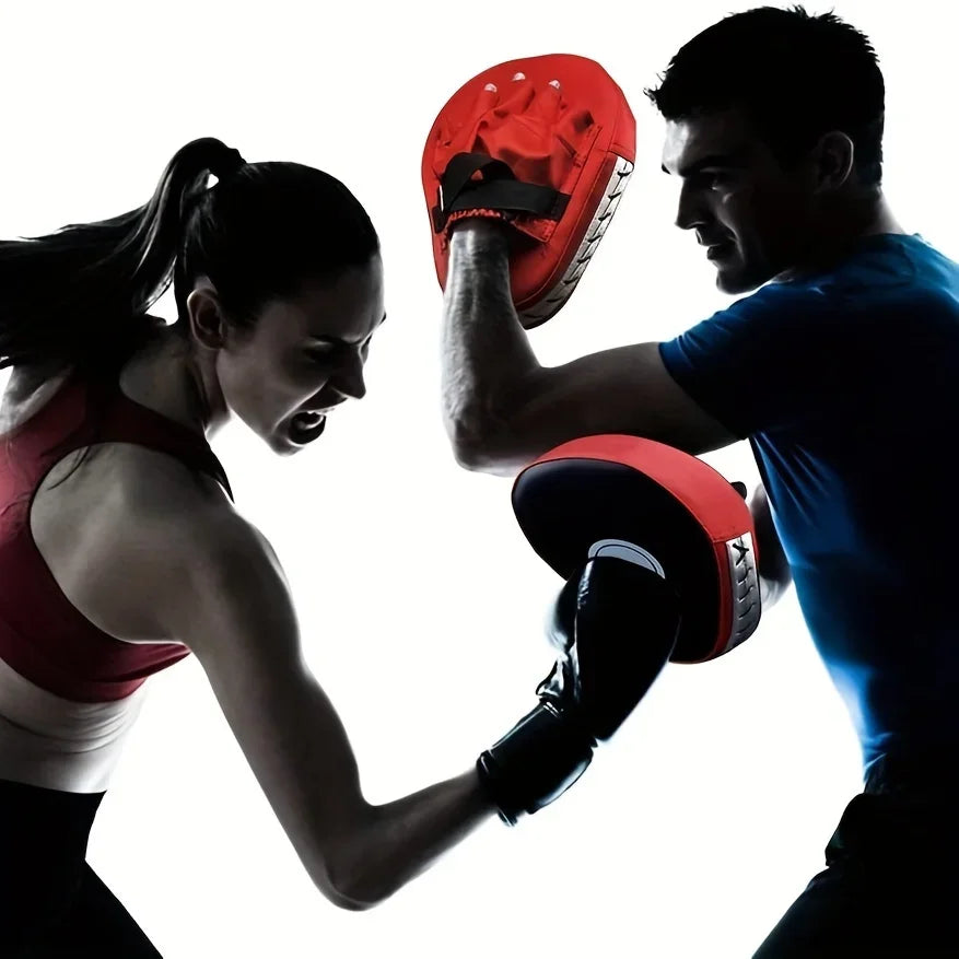Mujer boxeadora entrenando golpes con entrenador que sostiene manoplas rojas y negras